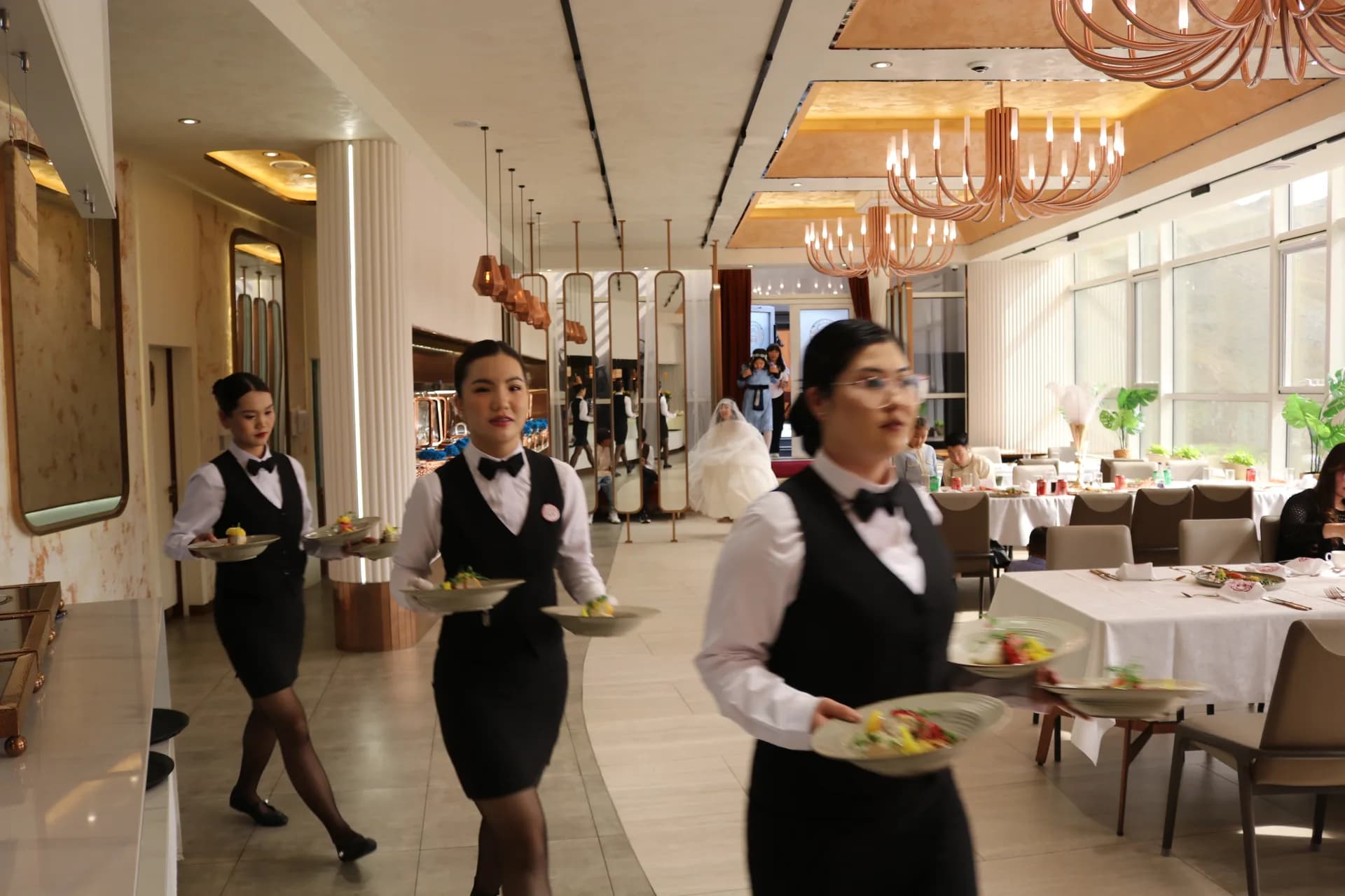 Choijin service team carrying dishes through the dining room