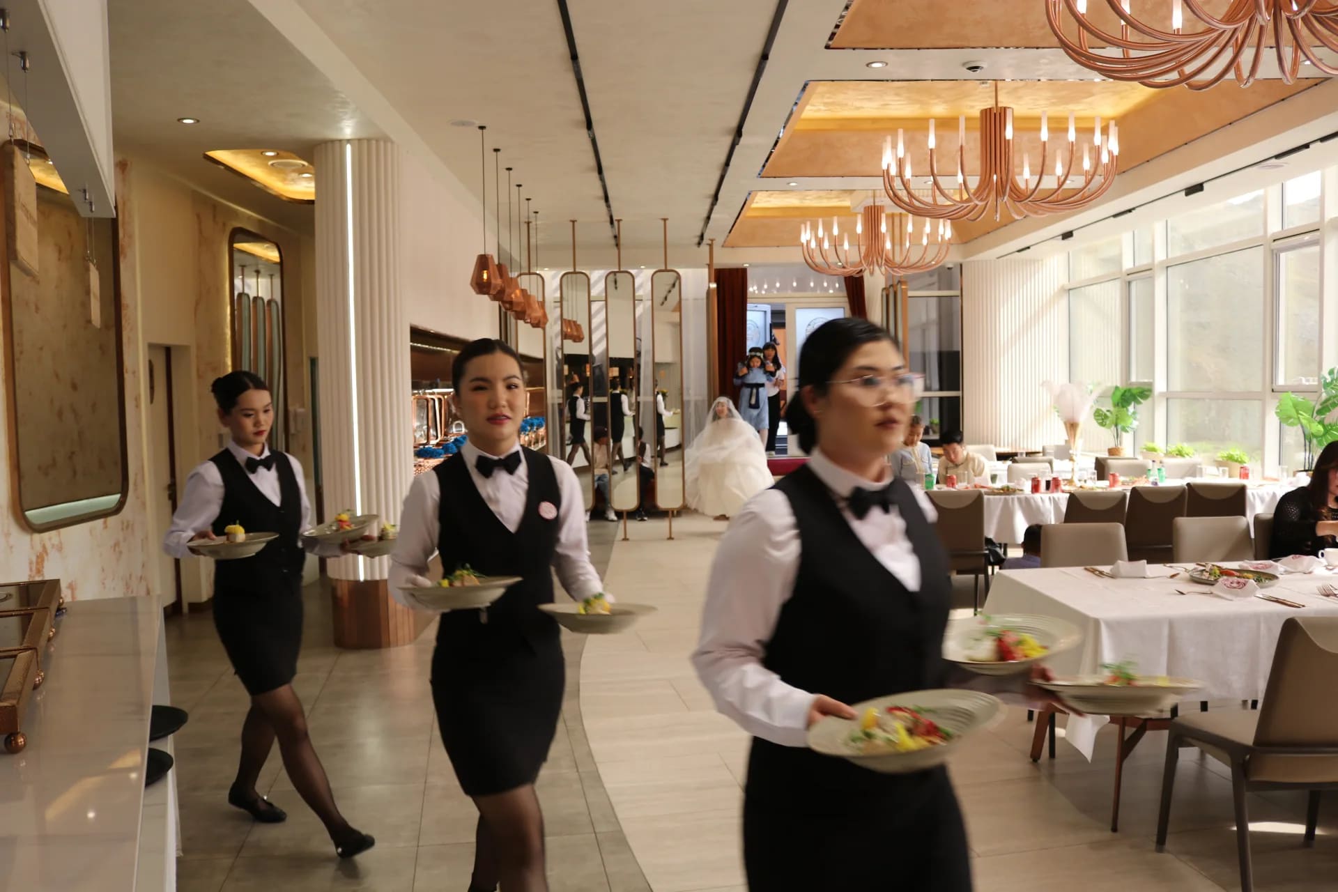 Choijin service team carrying dishes through the dining room